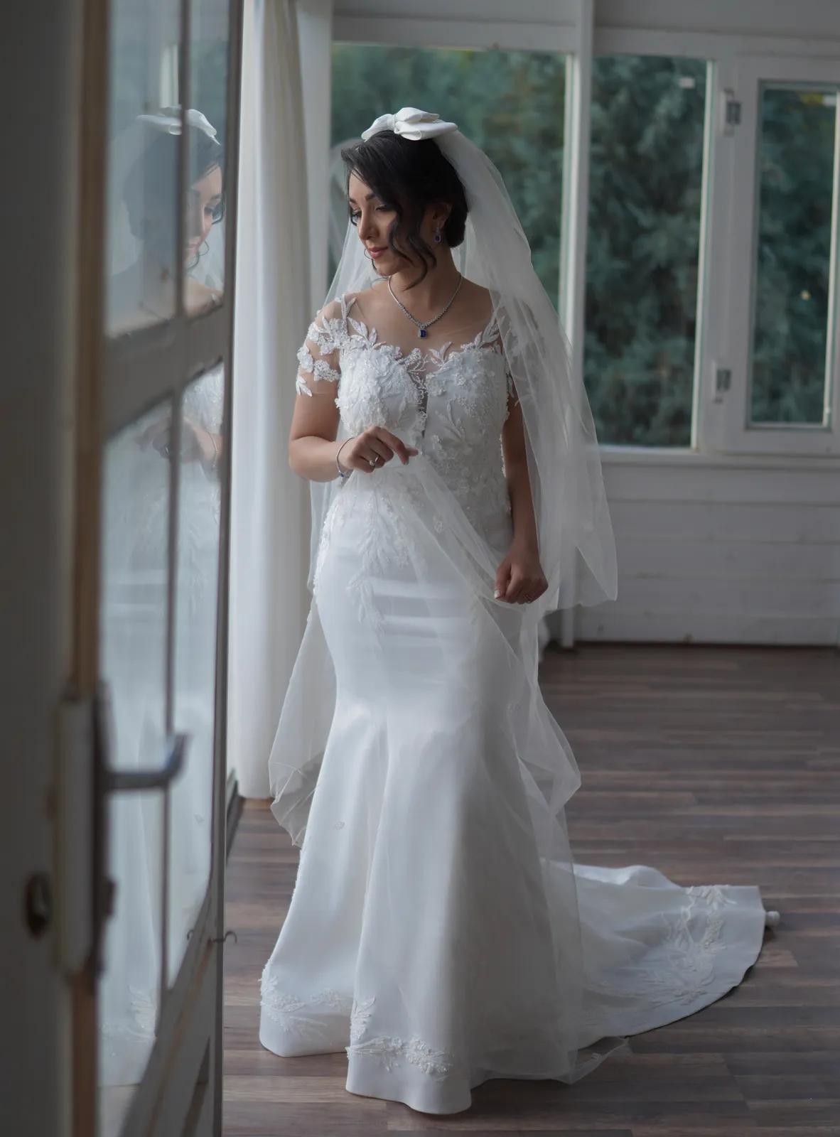 Bride in a custom fitted mermaid wedding dress with lace off-the-shoulder sleeves