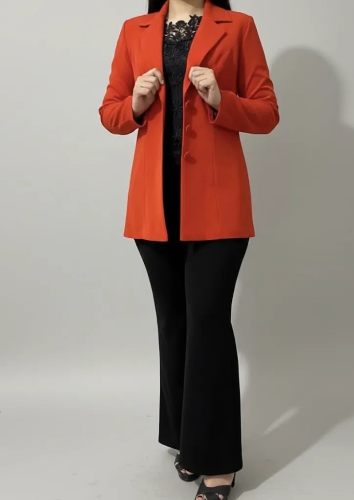 Tailored orange blazer worn over a black lace top and flared trousers