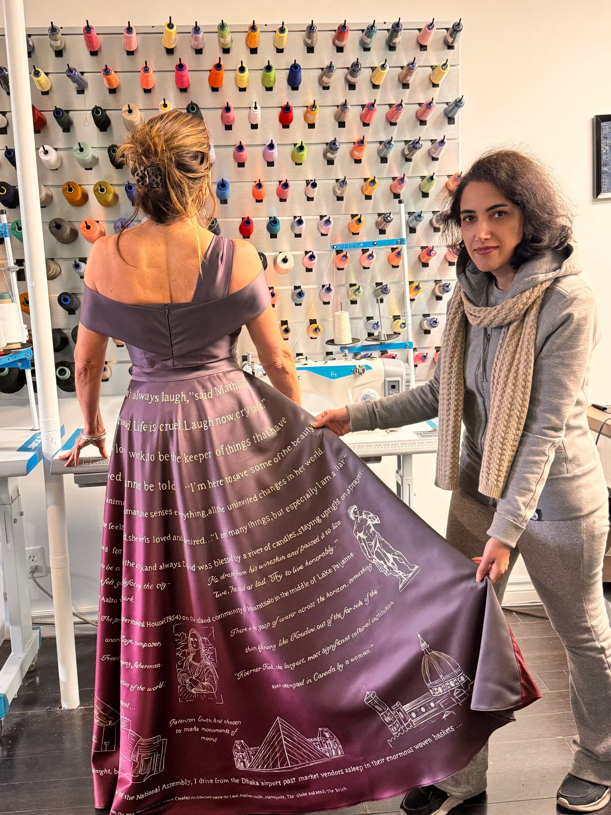 Dressmaker fitting a custom plum off-the-shoulder evening gown with a hand-printed skirt in the Toronto studio